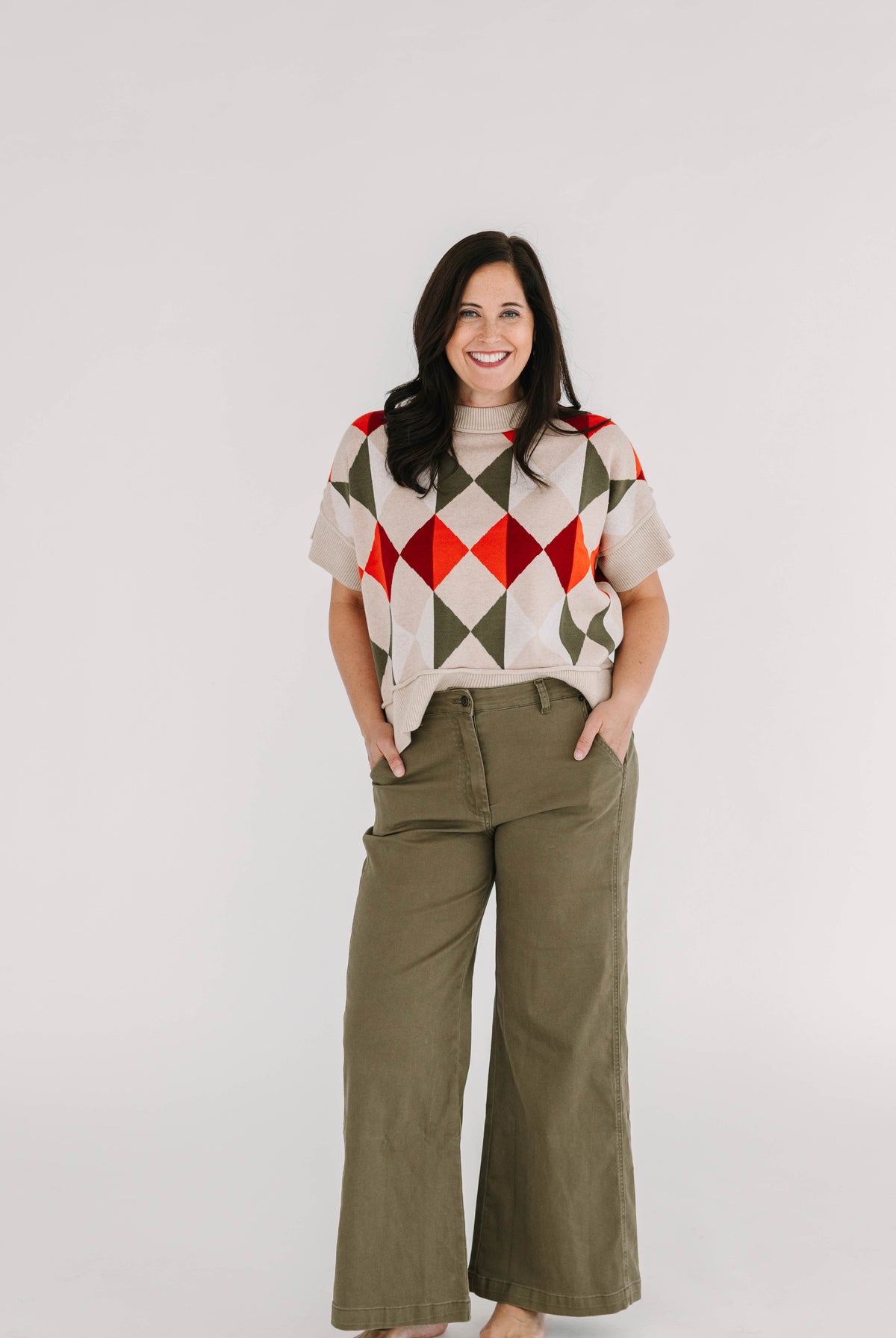 short sleeve relaxed fit sweater top with geometic orange and green pattern on taupe background
