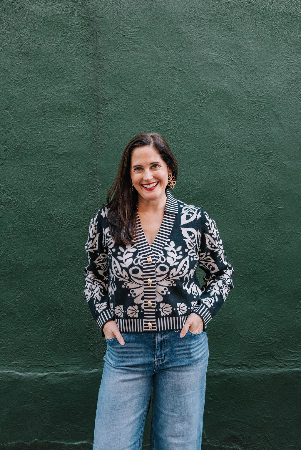 black and white v-neck cardigan sweater with gold buttons. Floral pattern with white stripe trim