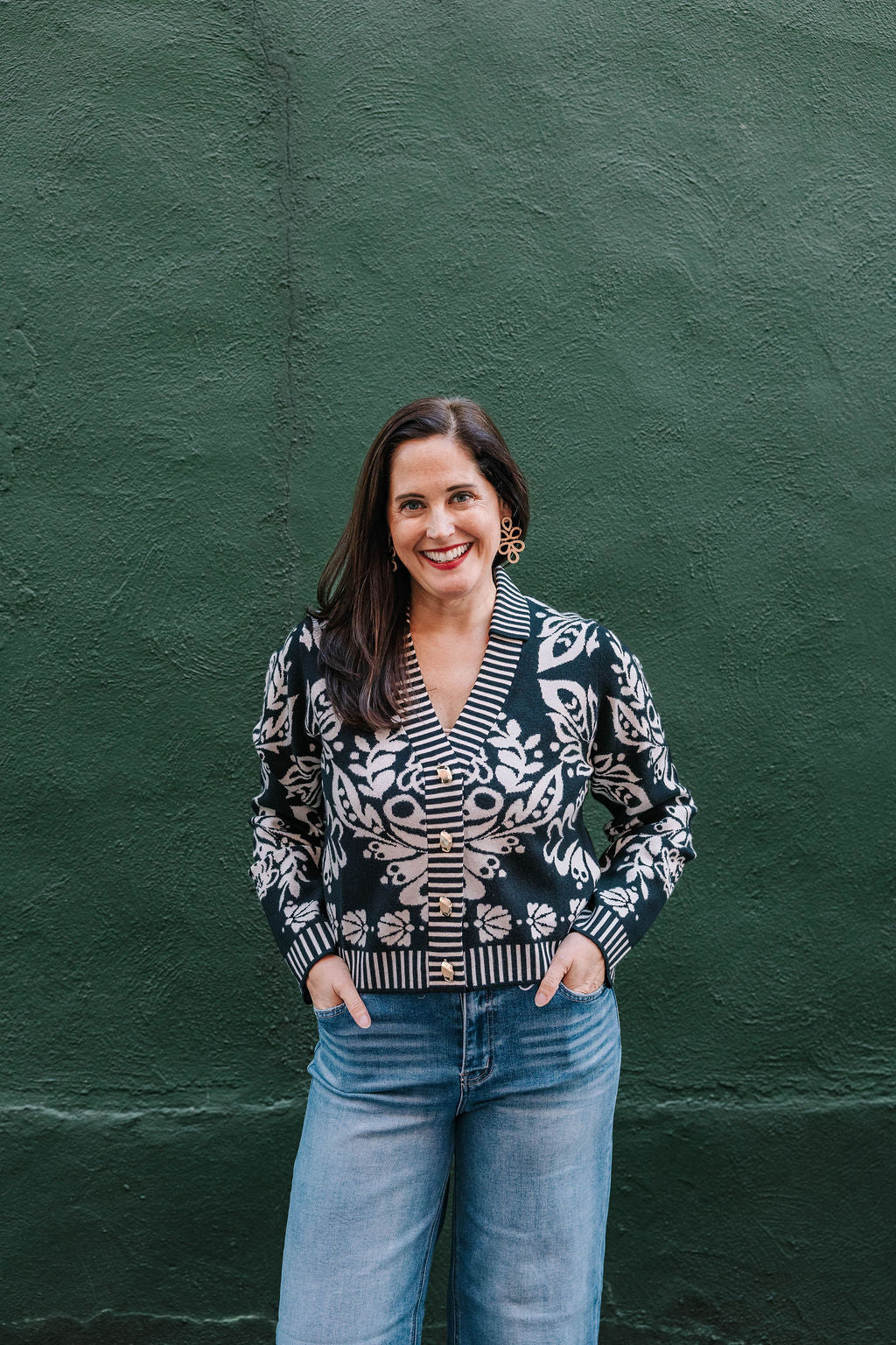 black and white v-neck cardigan sweater with gold buttons. Floral pattern with white stripe trim