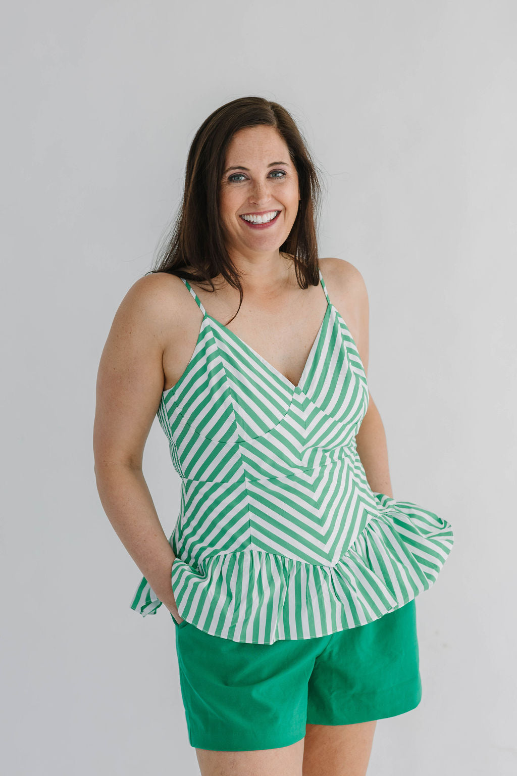 green and white chevron striped peplum top with fitted waist and spaghetti straps
stretch back with zipper closure