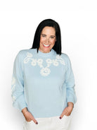 light blue sweater with white floral embroidery 