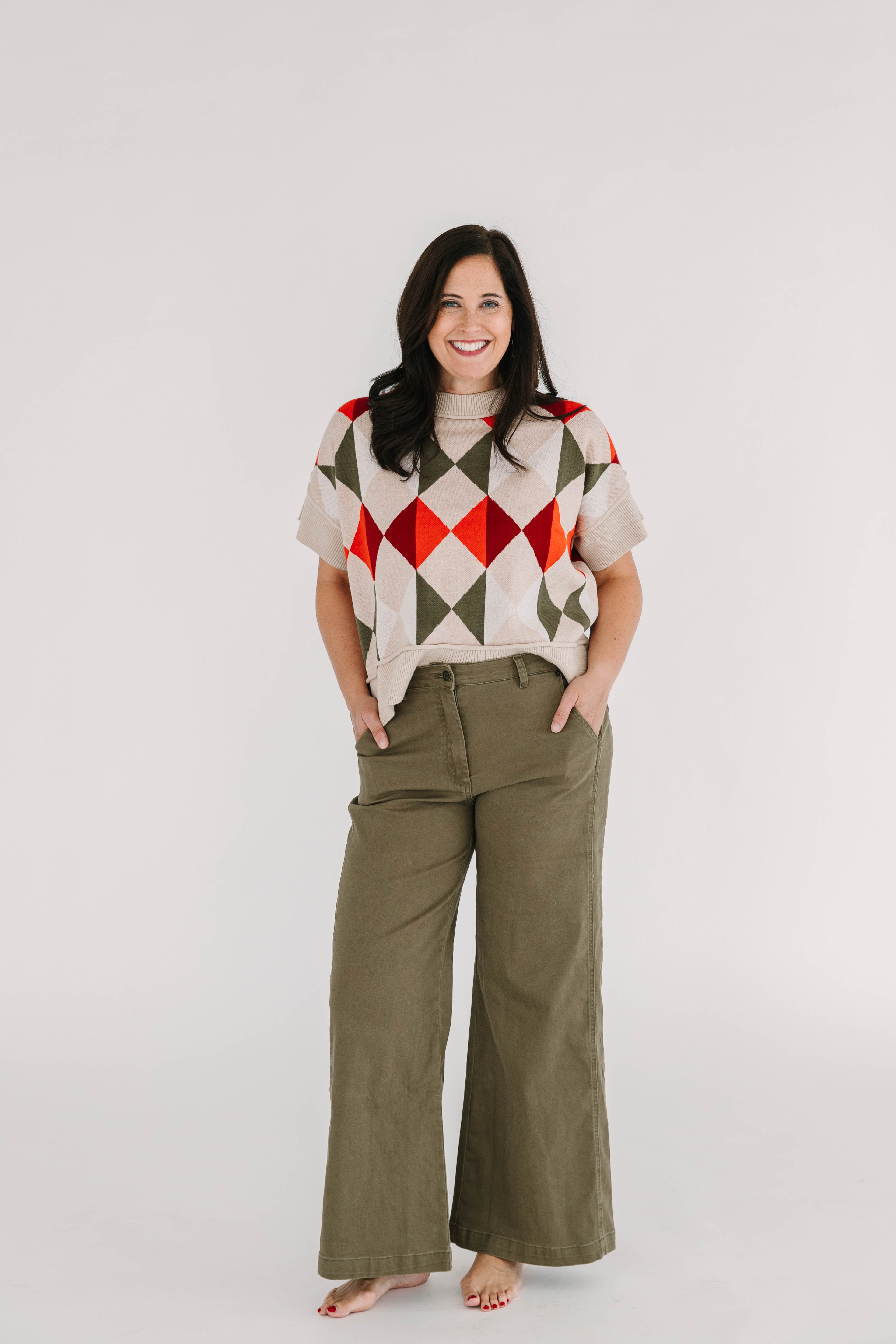 short sleeve relaxed fit sweater top with geometic orange and green pattern on taupe background