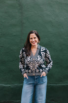 black and white v-neck cardigan sweater with gold buttons. Floral pattern with white stripe trim